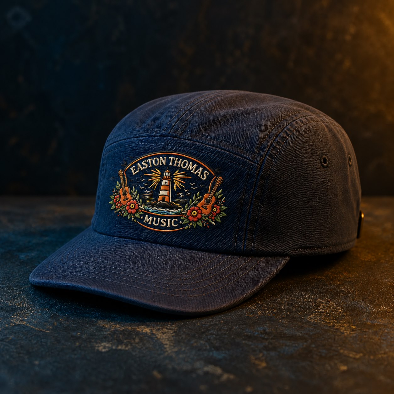 Dark navy cap with the Easton Thomas Music lighthouse logo embroidered on the front