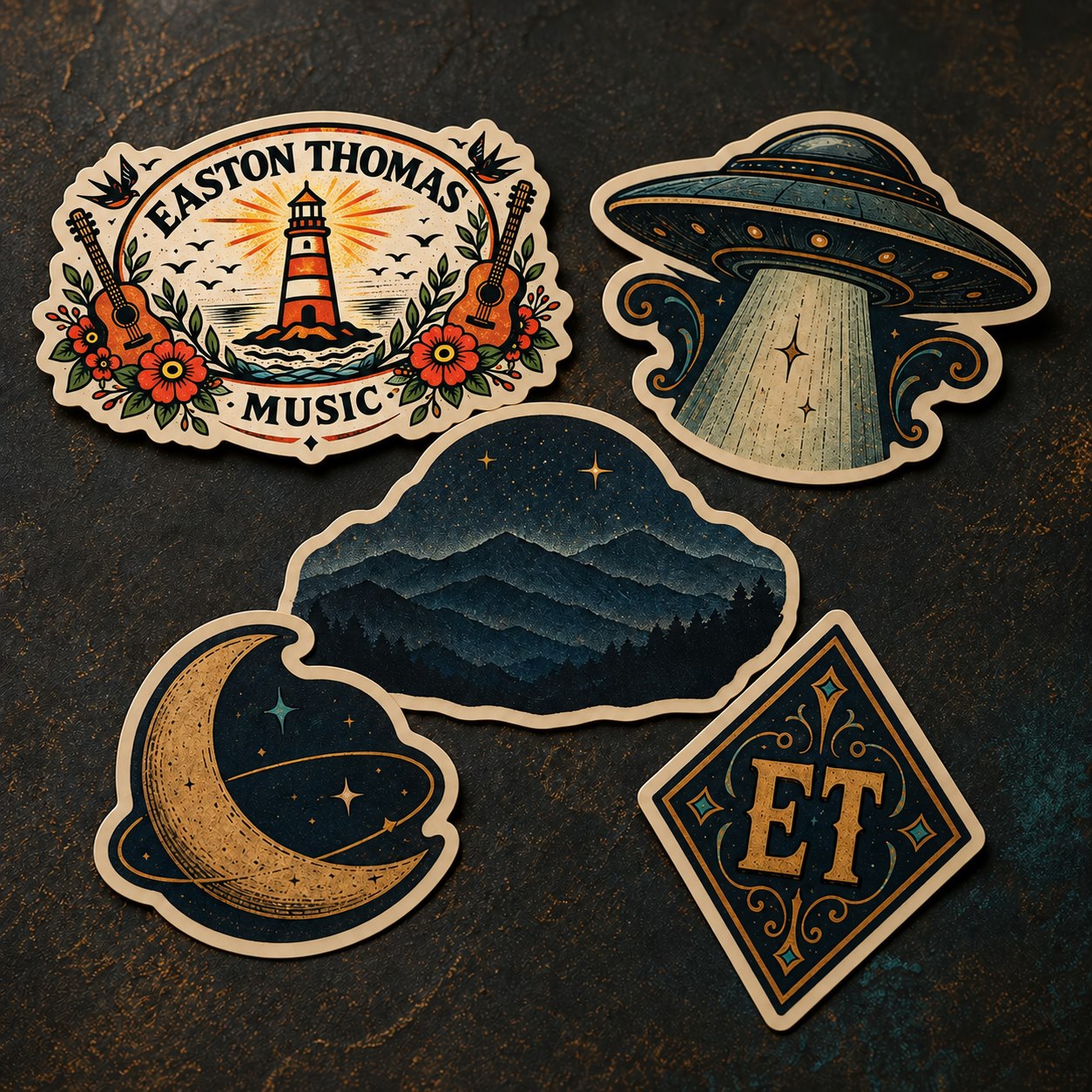 Five-piece sticker preview with the lighthouse logo, UFO, mountain landscape, crescent moon, and ET diamond emblem